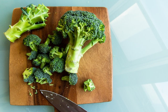broccoli on chopping board with knife
