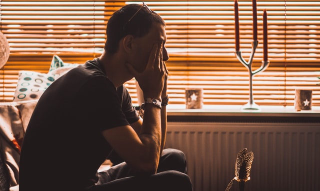 man holding head in hands