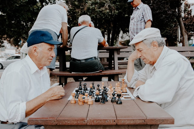 Old men playing chess outdoors